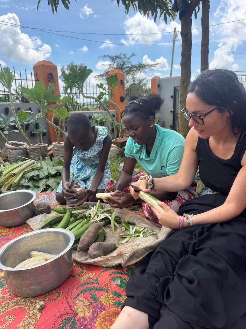 Volunteers preparing local food together at Kalule Bwaise Children Shelter