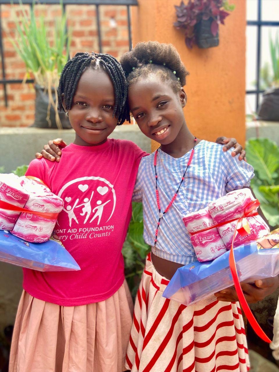 Two girls holding donated supplies together