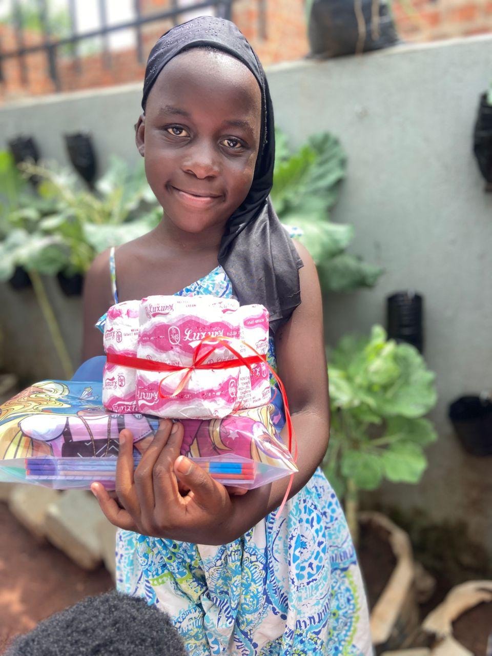 Smiling girl holding wrapped gifts and supplies