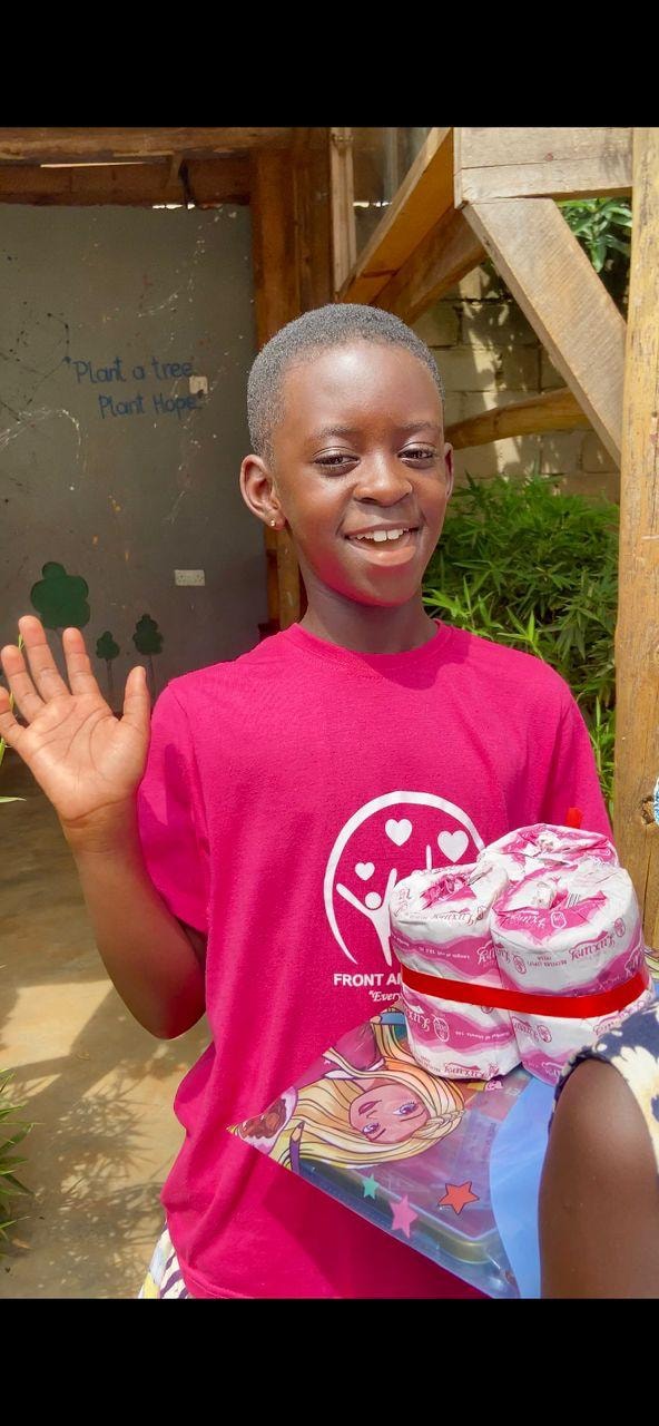 Smiling boy waving while holding wrapped gifts