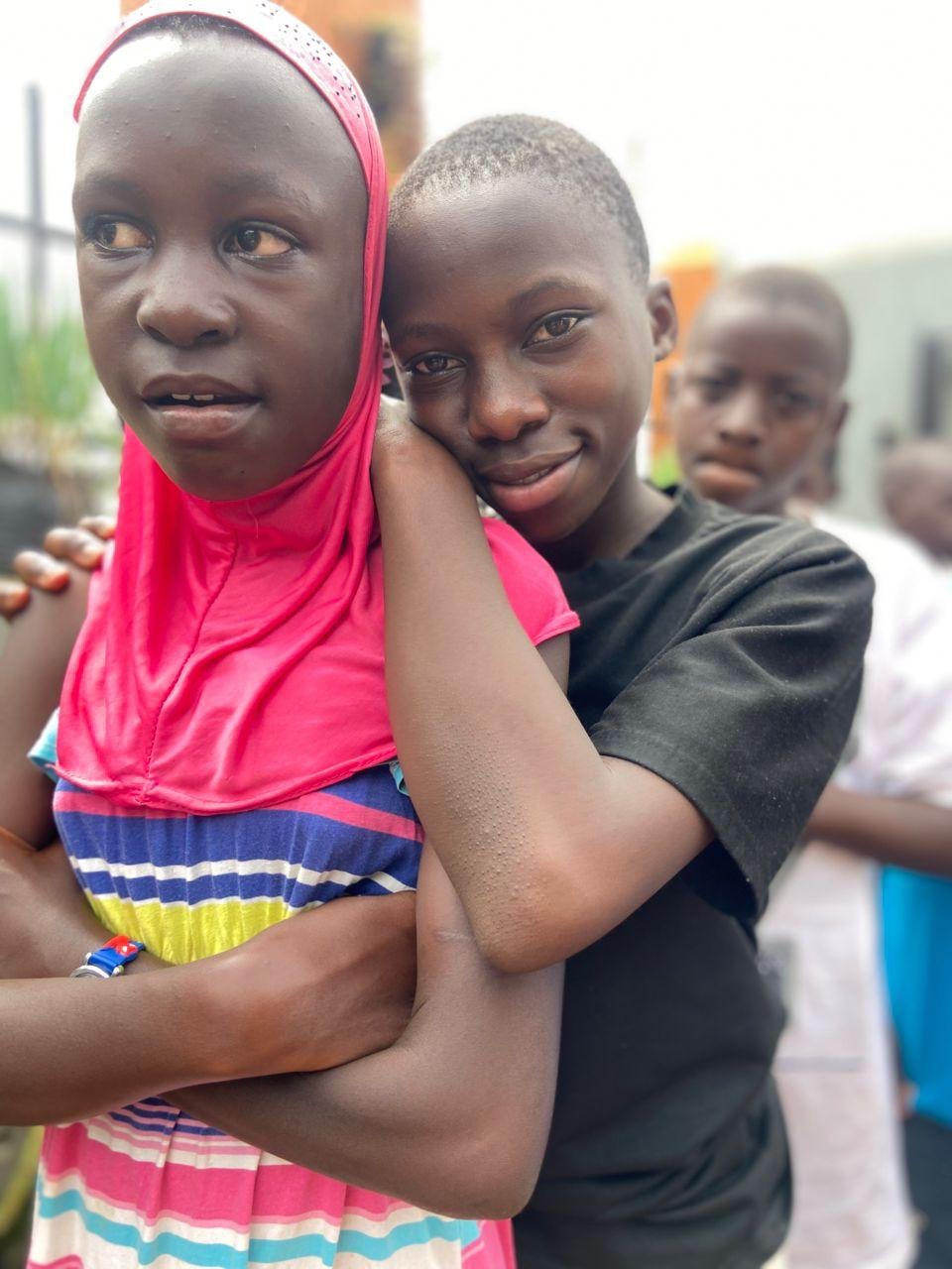 Children sharing a joyful embrace outdoors